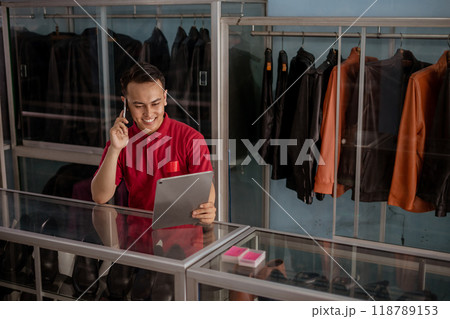 asian leather shoes store employee holding tablet and phone asian leather shoes store employee holding tablet and phone 118789153