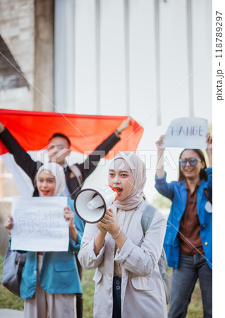 Youth activists rally for change, wielding megaphones and banners passionately Youth activists rally for change, wielding megaphones and banners passionately 118789297
