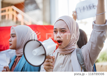 Empowered Voices Youth Protest for Change as They Utilize a Megaphone Loudly 118789306