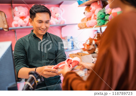 Asian man receives customer shopping item when customer to pay Asian man receives customer shopping item when customer to pay 118789723