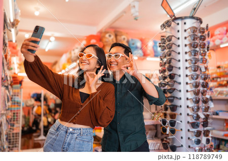handsome man and beautiful woman wearing cute glasses while selfie 118789749
