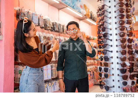 Asian man wears glasses while choosing with his girlfriend Asian man wears glasses while choosing with his girlfriend 118789752
