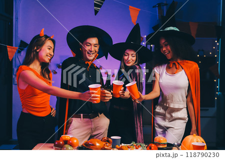 Joyful office Halloween party with coworkers in costumes, celebrating with drinks and laughter, fostering teamwork and festive spirit 118790230