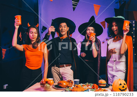 Joyful office Halloween party with coworkers in costumes, celebrating with drinks and laughter, fostering teamwork and festive spirit 118790233