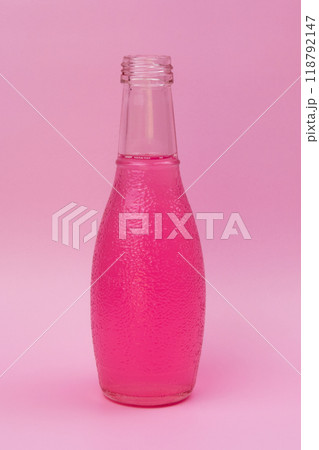 Transparent glass bottle with colorful liquid, unusual background 118792147
