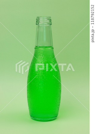 Transparent glass bottle with colorful liquid, unusual background 118792152