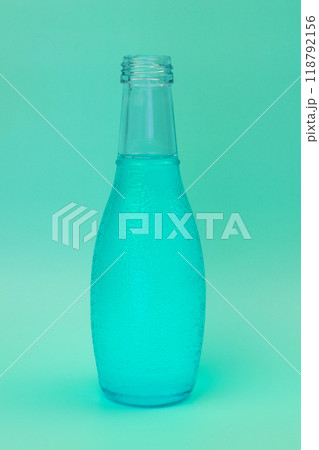 Transparent glass bottle with colorful liquid, unusual background Transparent glass bottle with colorful liquid, unusual background 118792156