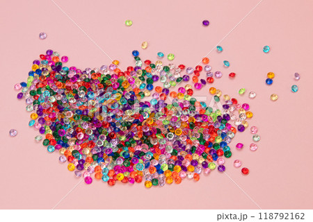 Multicolored tiny faceted crystals on a pink background, beautiful colorful texture Multicolored tiny faceted crystals on a pink background, beautiful colorful texture 118792162