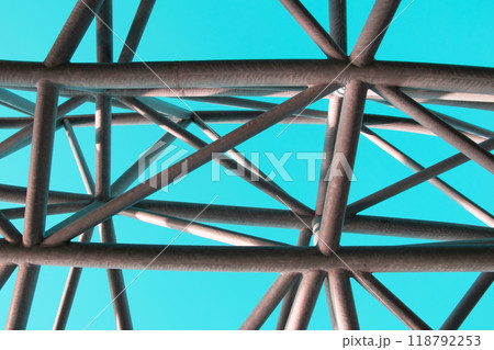 Abstract metal figure on a colorful pink background, artistically welded metal pipes, fragment of scaffolding in NYC 118792253