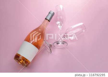 Wine bottle mockup, unopened bottle of rose wine and two glasses on pink background, top view, copy space, flat lay 118792295