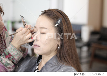 Concept of a beautiful Korean woman in her 30s getting her makeup done by a makeup artist, face before makeup Concept of a beautiful Korean woman in her 30s getting her makeup done by a makeup artist, face before makeup 118793663