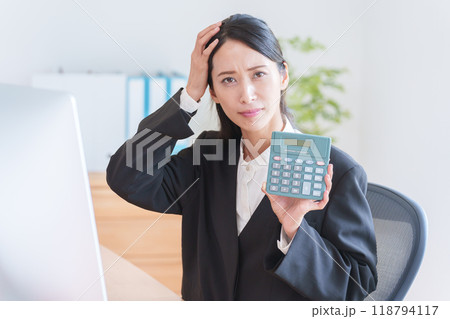 電卓を使って働くビジネスウーマン 118794117
