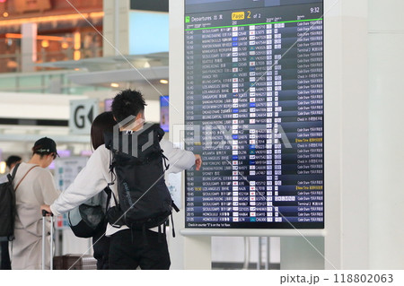 空港の時刻表を確認する旅行客　飛行機の時刻表 118802063