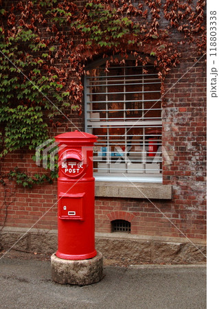 古い煉瓦の壁と赤い郵便ポスト 118803338