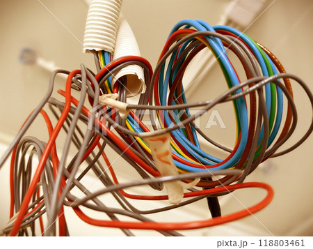 A collection of various wires is hanging down from the ceiling 118803461