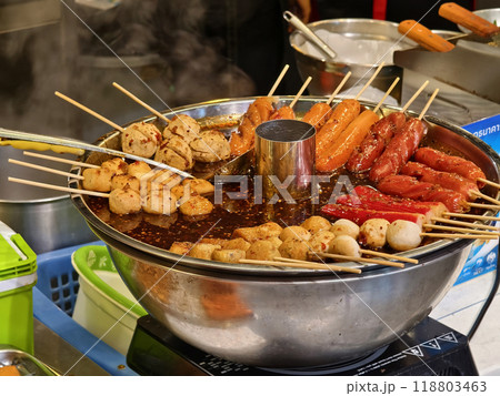 A large bowl is filled with delicious meatballs and sausages on sticks A large bowl is filled with delicious meatballs and sausages on sticks 118803463