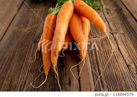 Bunch of fresh carrots from the farmer's market on wooden background. 118804579