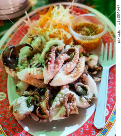 Plate of octopus with a fork and a container of sauce Plate of octopus with a fork and a container of sauce 118804947