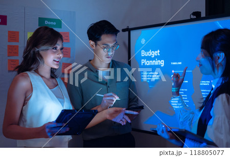 team of financial discussion budget planning, analyzing digital financial data and strategy in a modern office at night 118805077