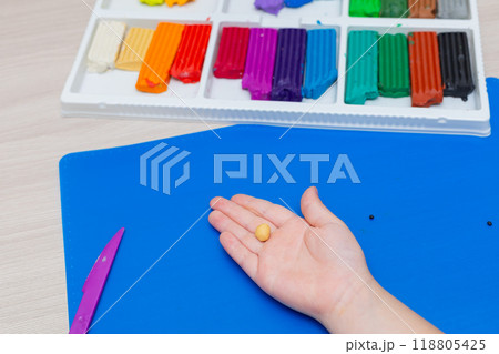 A box with colorful pieces of plasticine and a plastic knife for sculpting with plasticine. Topics of education and art A box with colorful pieces of plasticine and a plastic knife for sculpting with plasticine. Topics of education and art 118805425