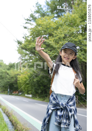 田舎の通学路の森の中を歩く、ランドセルを背負った、下校中の小学生の女の子 田舎の通学路の森の中を歩く、ランドセルを背負った、下校中の小学生の女の子 118805876