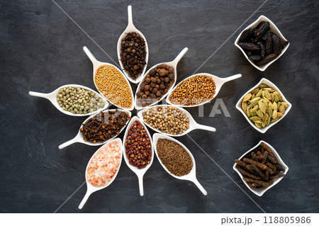 Exotic spices in white porcelain bowls on a slate plate Exotic spices in white porcelain bowls on a slate plate 118805986