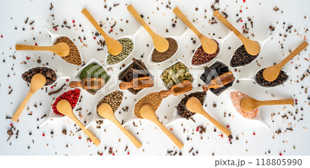 Many different spices in porcelain bowls with wooden spoons Many different spices in porcelain bowls with wooden spoons 118805990