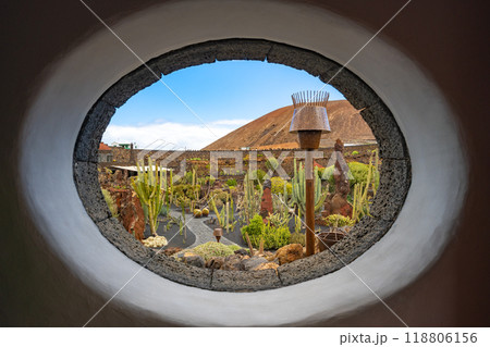 View through an oval window at the entrance to the  cactus garden Jardin de Cactus of Lanzarote 118806156