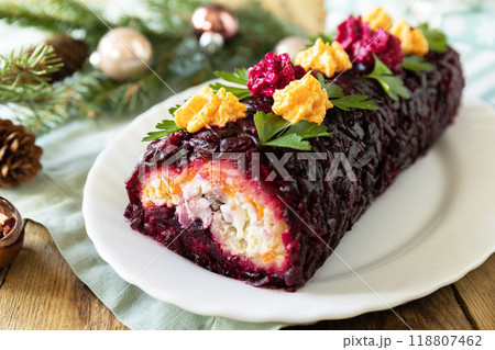 Christmas appetizer New year meal idea. Festive layered salad. Christmas New Year vegetable salad roll with herring and boiled vegetables. 118807462