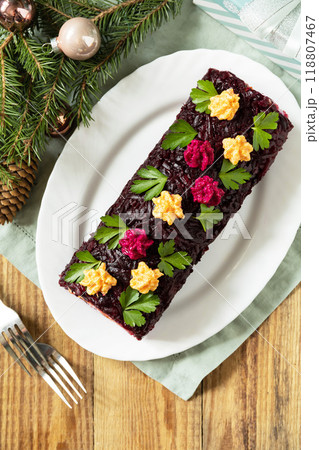Christmas appetizer New year meal idea. Festive layered salad. Christmas New Year vegetable salad roll with herring and boiled vegetables. Christmas appetizer New year meal idea. Festive layered salad. Christmas New Year vegetable salad roll with herring and boiled vegetables. 118807467