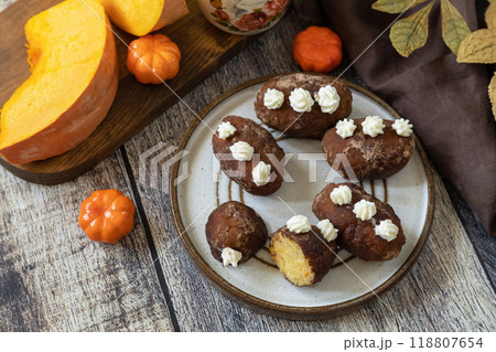 Chocolate rum potato cake with pumpkin on rustic background, homemade vegan dessert. Traditional Eastern European dish with cocoa and butter. Chocolate sweets filled with marzipan. 118807654
