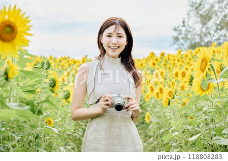 ひまわり畑でカメラを構える女性 118808283