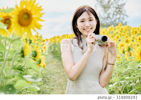 ひまわり畑でカメラを構える女性 118808291
