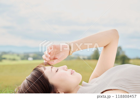 大自然をバックに寝転ぶ若い女性 118808457