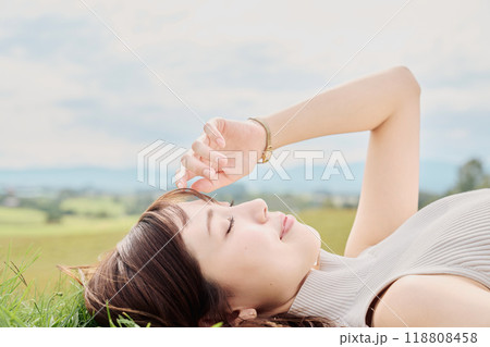 大自然をバックに寝転ぶ若い女性 118808458