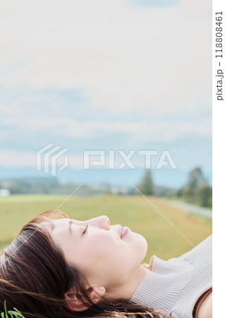 大自然をバックに寝転ぶ若い女性 大自然をバックに寝転ぶ若い女性 118808461