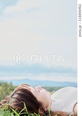 大自然をバックに寝転ぶ若い女性 118808462