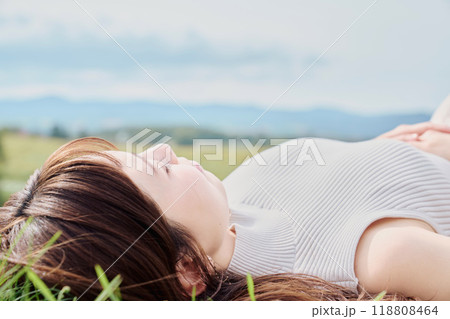 大自然をバックに寝転ぶ若い女性 118808464