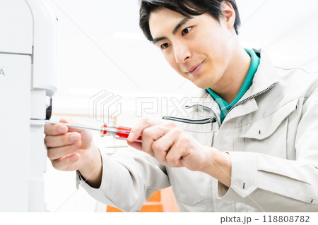 コピー機をメンテナンスするサービスマン 118808782