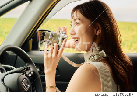 車の中から写真を撮る若い女性 118809297