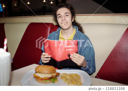 Reading Horror Story Book While Eating Burger and Fries Reading Horror Story Book While Eating Burger and Fries 118811108