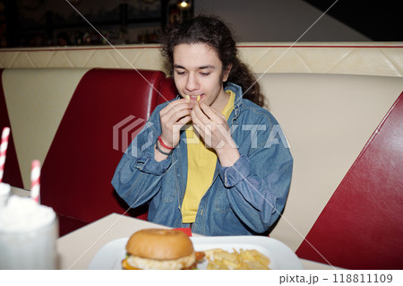 Portrait of Teenager Eating French Fries in Diner Booth Portrait of Teenager Eating French Fries in Diner Booth 118811109