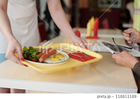 Serving Breakfast Plate Containing Sausages and Fried Eggs Serving Breakfast Plate Containing Sausages and Fried Eggs 118811189