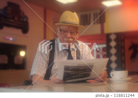 Reading Newspaper in Cozy Coffee Shop Setting Reading Newspaper in Cozy Coffee Shop Setting 118811244