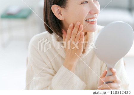 鏡を見てスキンケアをする女性 鏡を見てスキンケアをする女性 118812420
