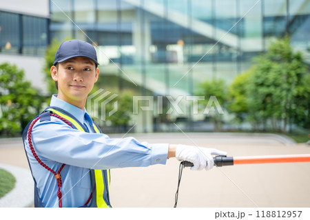 誘導棒を持って交通誘導をするガードマン男性 118812957