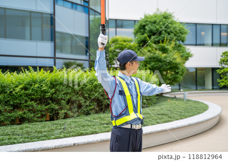 誘導棒を持って交通誘導をするガードマン男性 誘導棒を持って交通誘導をするガードマン男性 118812964