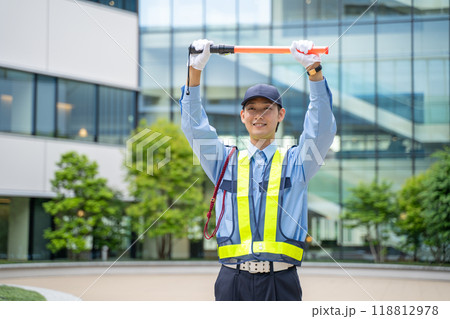 誘導棒を持って交通誘導をするガードマン男性 118812978