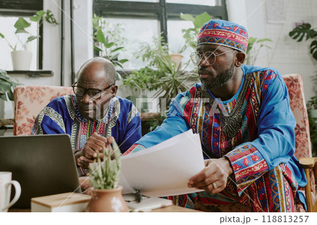 African American male workers sitting in coworking zone and looking at screen, they reading content of new project African American male workers sitting in coworking zone and looking at screen, they reading content of new project 118813257