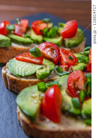 Avocado toast topped with tomato and green onion on a slice of carrot bread Avocado toast topped with tomato and green onion on a slice of carrot bread 118814717